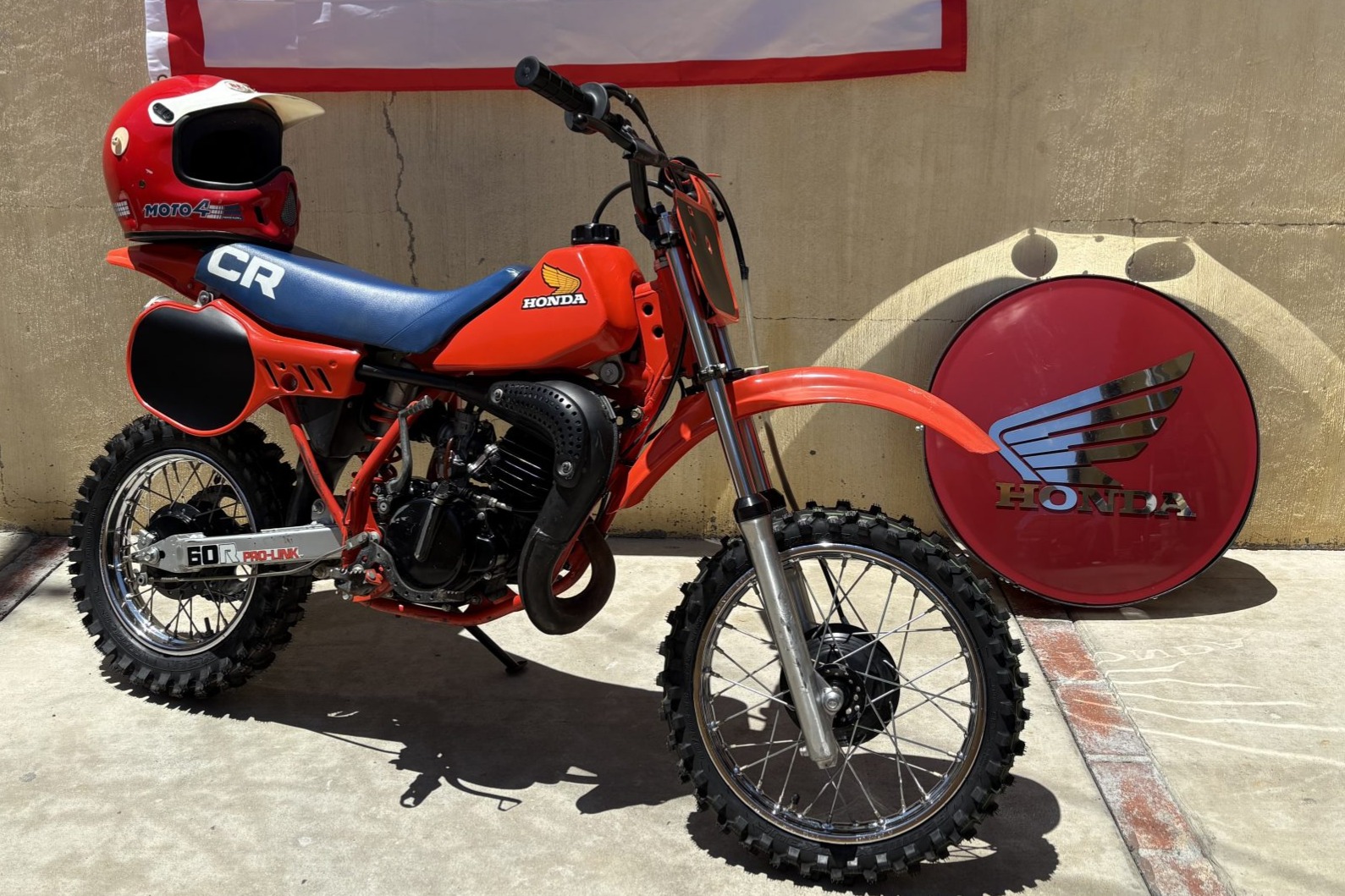 No Reserve: 1983 Honda CR60R, Honda Sign, and Moto4 Helmet